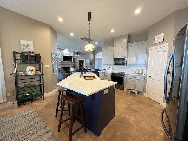 kitchen featuring white cabinetry, sink, pendant lighting, a center island with sink, and black appliances