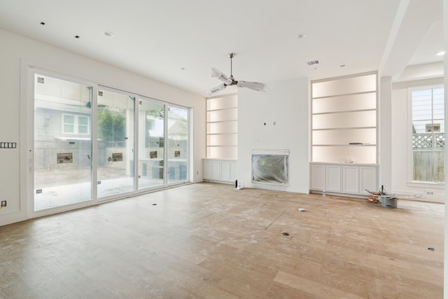 unfurnished living room with ceiling fan