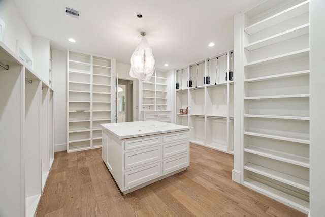 walk in closet with light hardwood / wood-style flooring