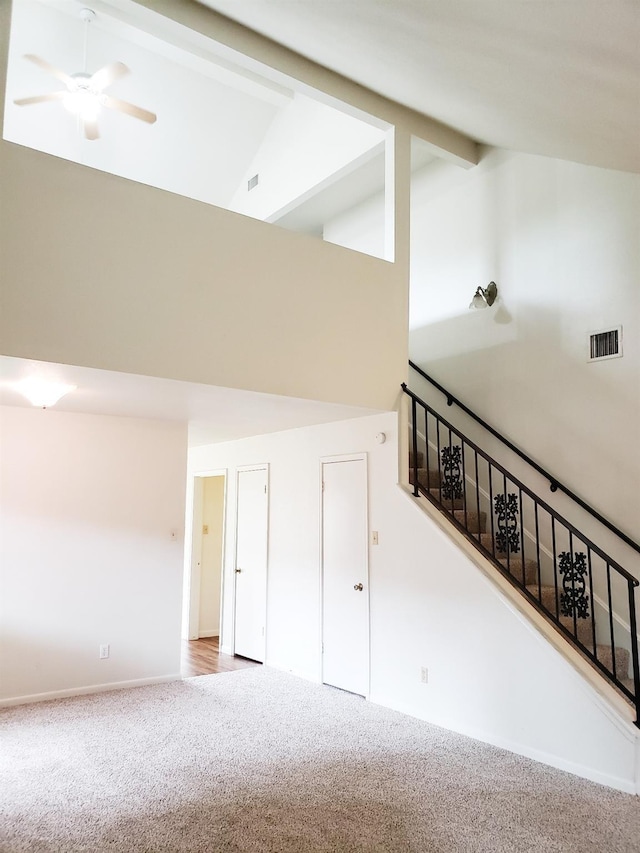 interior space featuring carpet flooring, lofted ceiling with beams, and ceiling fan