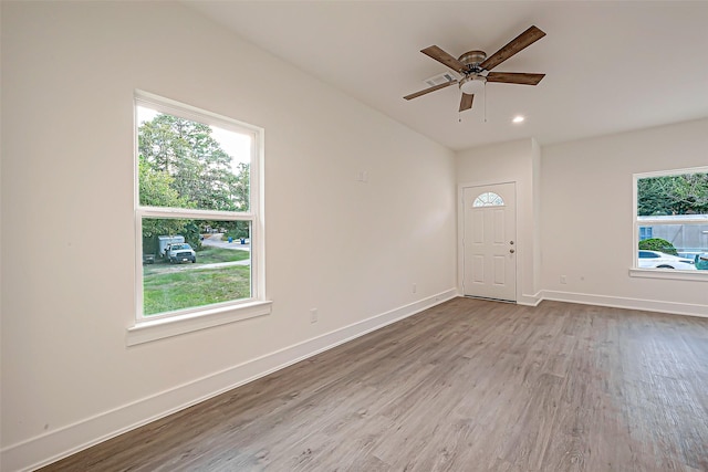 unfurnished room with ceiling fan, a wealth of natural light, and light hardwood / wood-style flooring