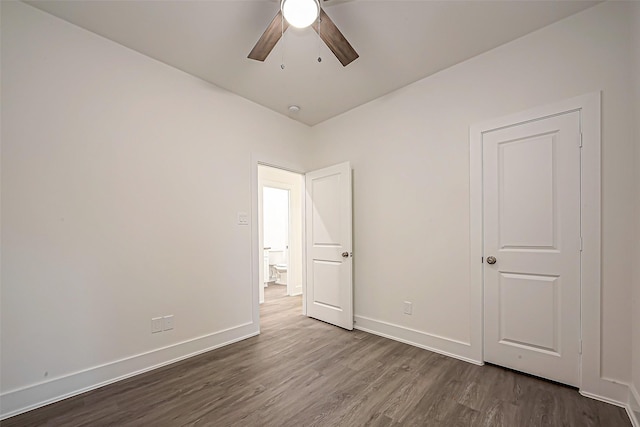 spare room with dark hardwood / wood-style flooring and ceiling fan