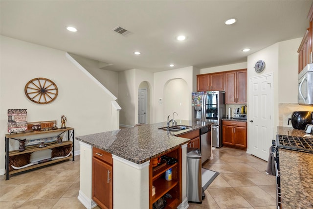 kitchen featuring sink, light tile patterned floors, a kitchen island with sink, and stainless steel appliances