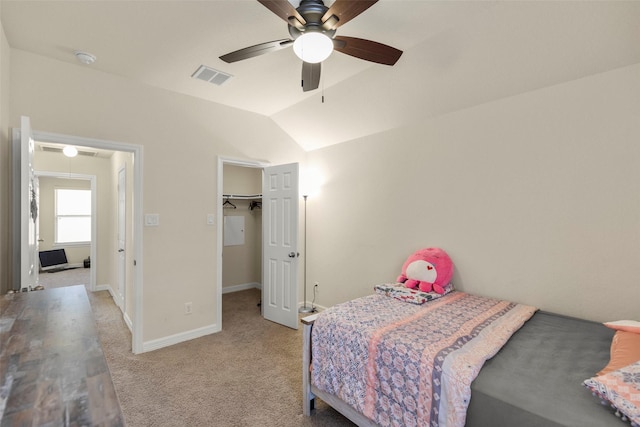 carpeted bedroom featuring ceiling fan, a closet, a spacious closet, and vaulted ceiling