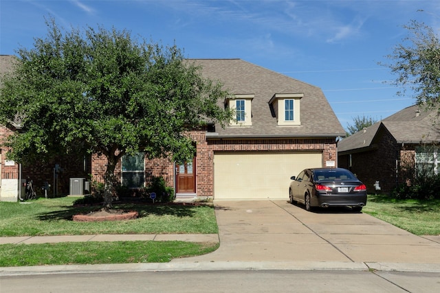 view of front of house with central AC unit, a garage, and a front lawn