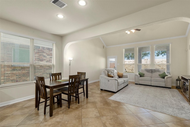 tiled dining area with ceiling fan and vaulted ceiling