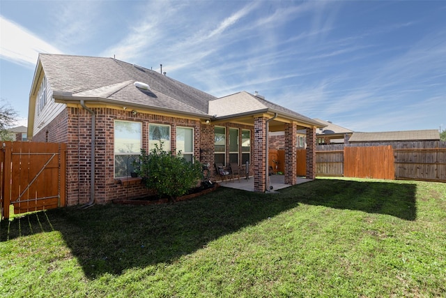 back of house with a patio area and a yard