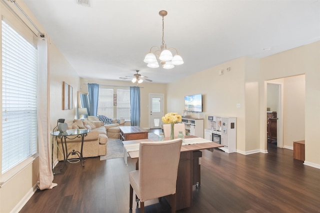 dining space with ceiling fan with notable chandelier and dark hardwood / wood-style floors