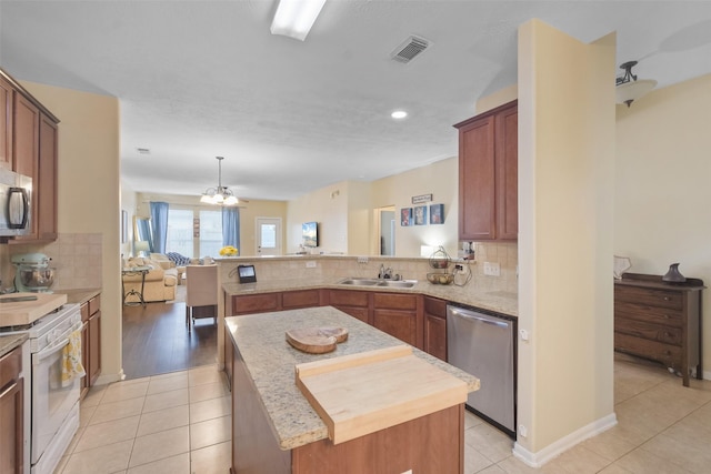 kitchen with decorative backsplash, sink, a center island, and appliances with stainless steel finishes