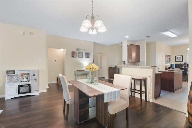 dining space with wood-type flooring and a chandelier