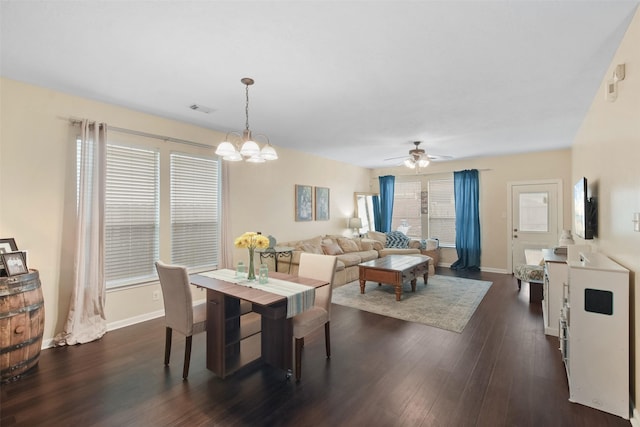 dining area featuring ceiling fan with notable chandelier, plenty of natural light, and dark wood-type flooring