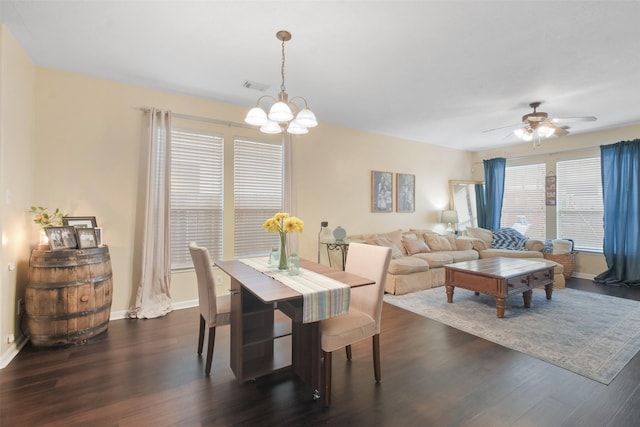 dining area featuring ceiling fan with notable chandelier and dark hardwood / wood-style floors