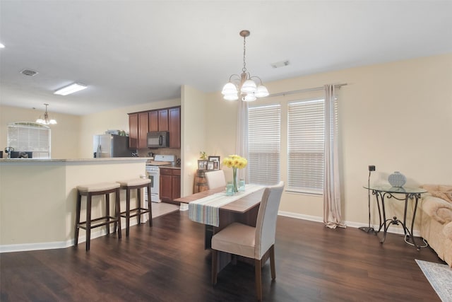 dining room featuring dark wood-type flooring and an inviting chandelier