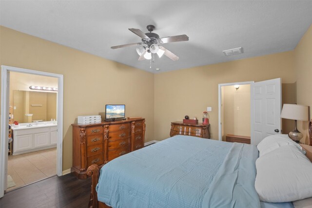 bedroom featuring ceiling fan, dark wood-type flooring, and connected bathroom