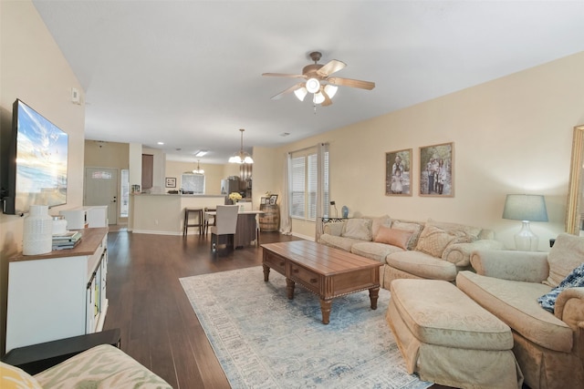 living room with wood-type flooring and ceiling fan with notable chandelier