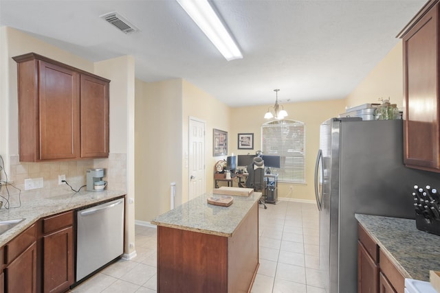 kitchen featuring light tile patterned floors, a notable chandelier, dishwasher, a center island, and hanging light fixtures