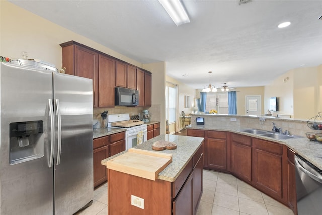 kitchen featuring sink, a center island, light tile patterned floors, and appliances with stainless steel finishes