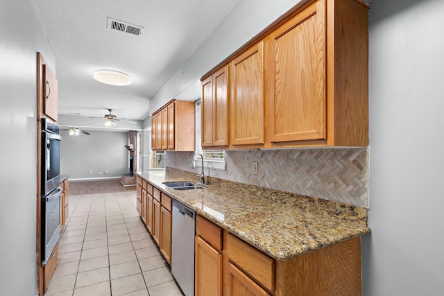 kitchen with sink, light stone counters, tasteful backsplash, light tile patterned floors, and stainless steel appliances