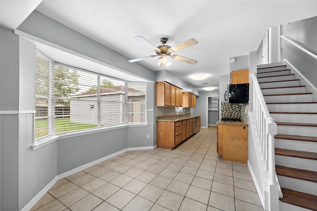 kitchen with light tile patterned flooring, ceiling fan, plenty of natural light, and backsplash