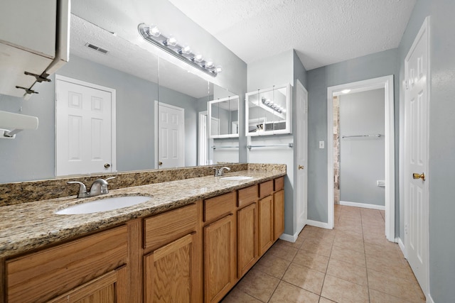 bathroom with vanity, tile patterned floors, and a textured ceiling