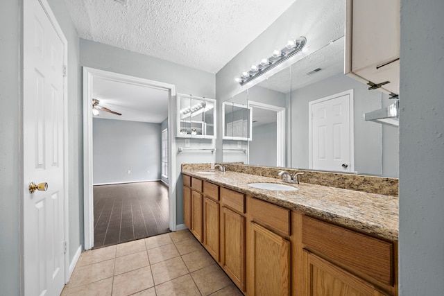 bathroom featuring vanity, ceiling fan, tile patterned floors, and a textured ceiling