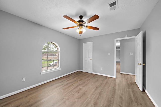 unfurnished bedroom with ceiling fan, light hardwood / wood-style floors, and a textured ceiling