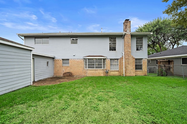 rear view of property with a lawn