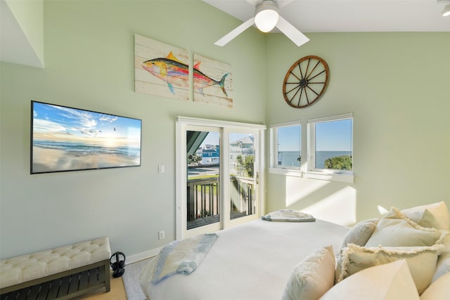 bedroom with access to outside, wood finished floors, baseboards, and high vaulted ceiling