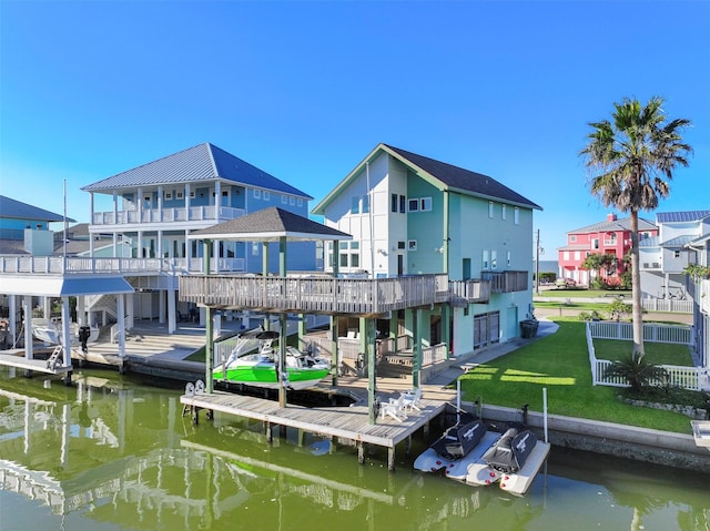 dock area featuring a residential view, a balcony, a yard, and a water view