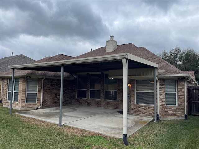 back of house with a lawn and a patio