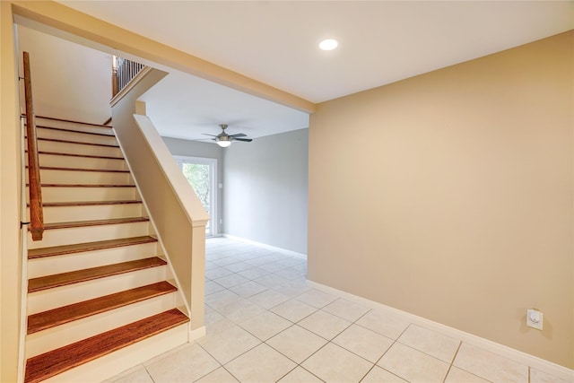 stairway featuring tile patterned flooring and ceiling fan