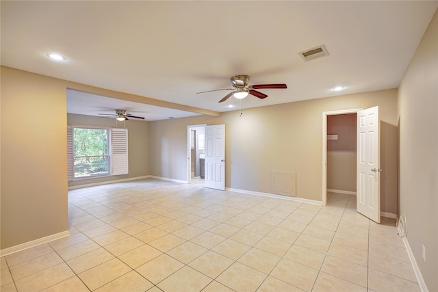 empty room with ceiling fan and light tile patterned flooring