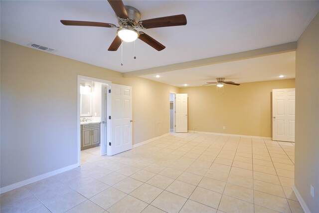 unfurnished room with sink, ceiling fan, and light tile patterned floors