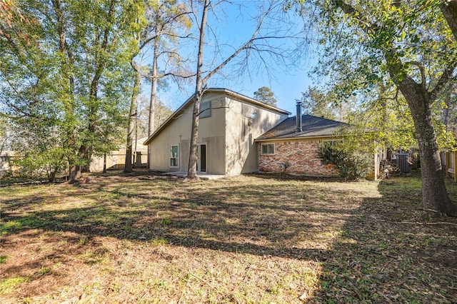 rear view of house featuring central AC and a yard