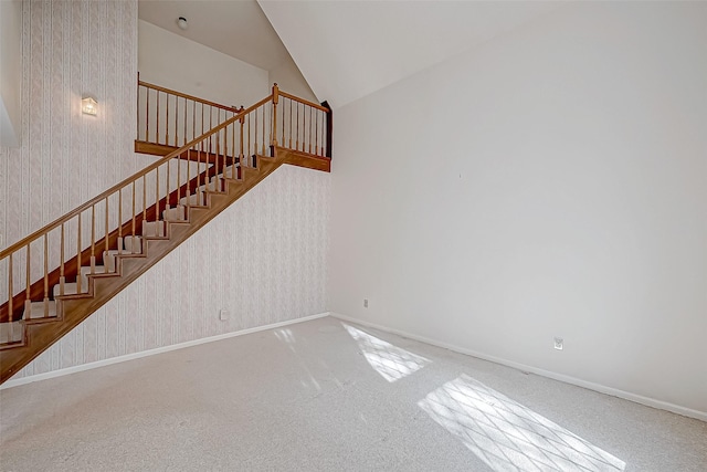 staircase featuring lofted ceiling and carpet floors