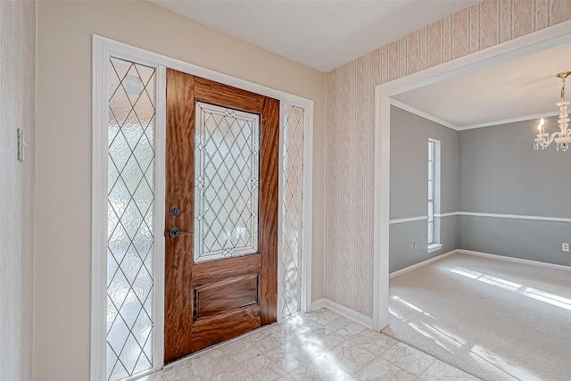 entryway with a notable chandelier, crown molding, and a wealth of natural light