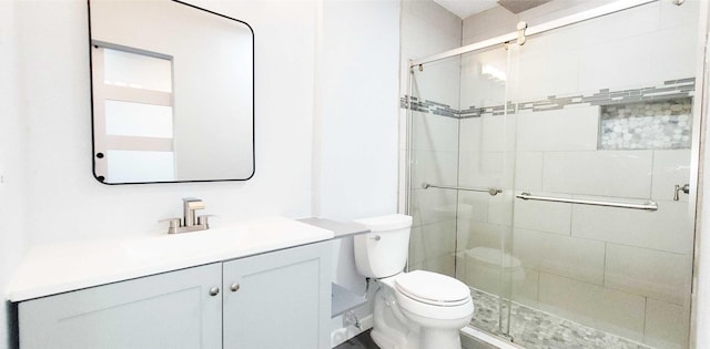 bathroom featuring vanity, an enclosed shower, and toilet