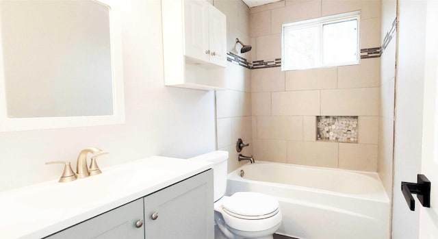 full bathroom featuring tiled shower / bath, vanity, and toilet