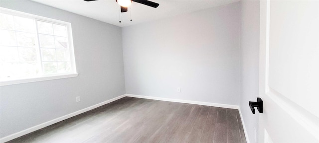 spare room featuring dark wood-type flooring and ceiling fan