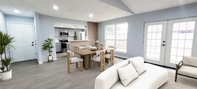 dining space with light hardwood / wood-style flooring and french doors