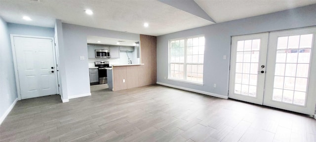 kitchen with french doors, stainless steel appliances, light hardwood / wood-style floors, and gray cabinetry