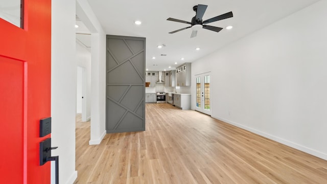 unfurnished living room featuring ceiling fan and light hardwood / wood-style floors