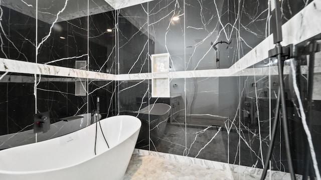 bathroom with a tub and tile walls