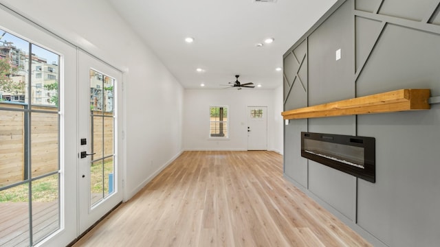 unfurnished living room featuring ceiling fan and light hardwood / wood-style flooring