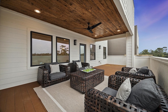 deck at dusk with an outdoor hangout area and ceiling fan