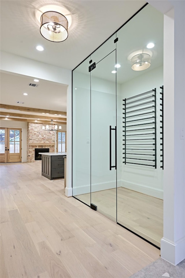 interior space with french doors, a brick fireplace, and hardwood / wood-style floors