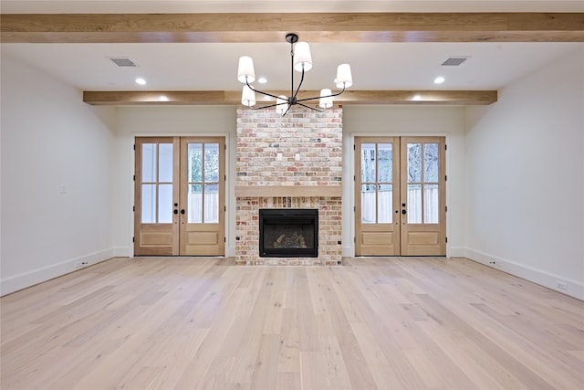 unfurnished living room with plenty of natural light, french doors, and beamed ceiling