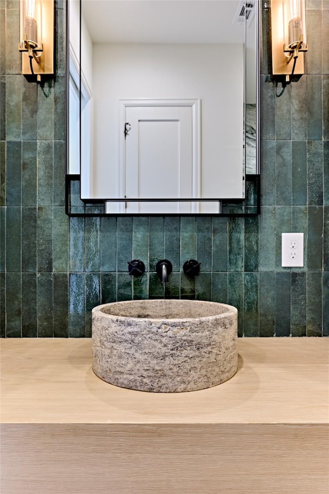 interior space with tile walls, sink, and decorative backsplash