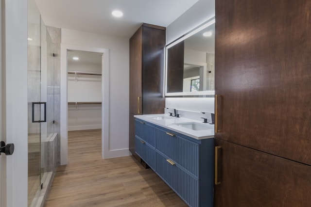 bathroom featuring vanity, wood-type flooring, and walk in shower