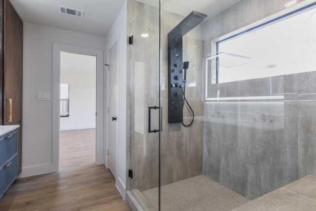 bathroom with vanity, a shower with door, and wood-type flooring